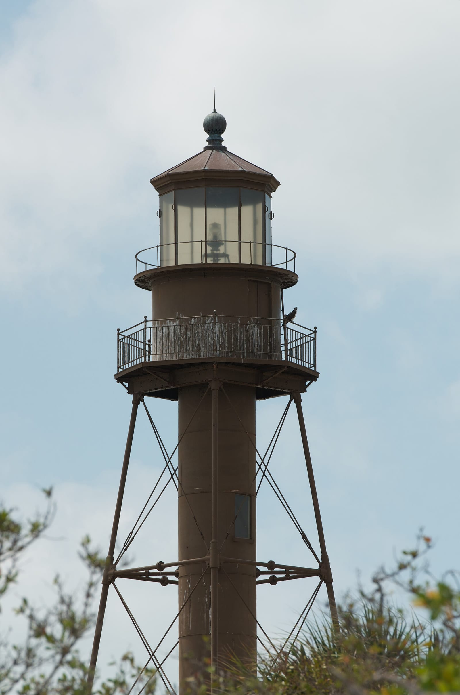 The iron-pile Sanibel Island lighthouse tower rising above the island brush on Sanibel, Florida